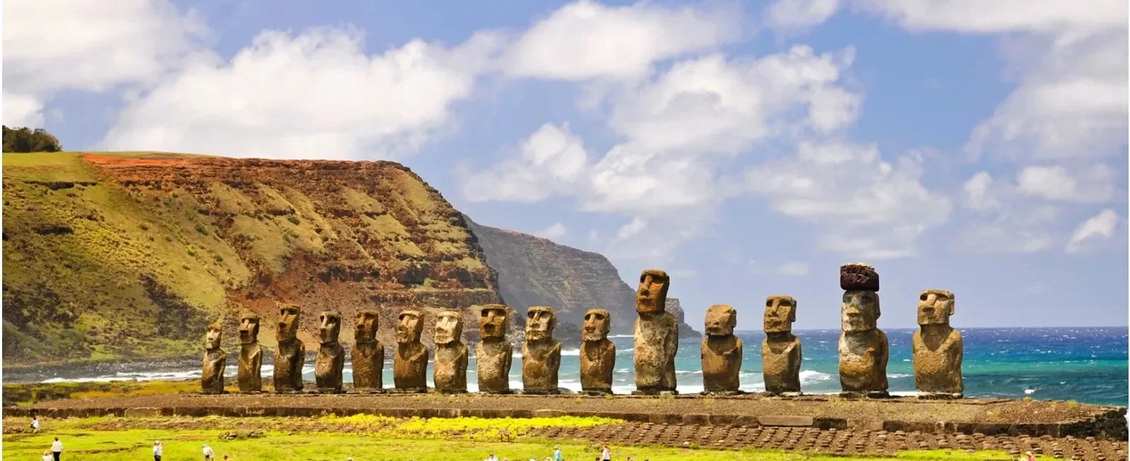 Moai statues standing on Easter Island with tourists nearby.